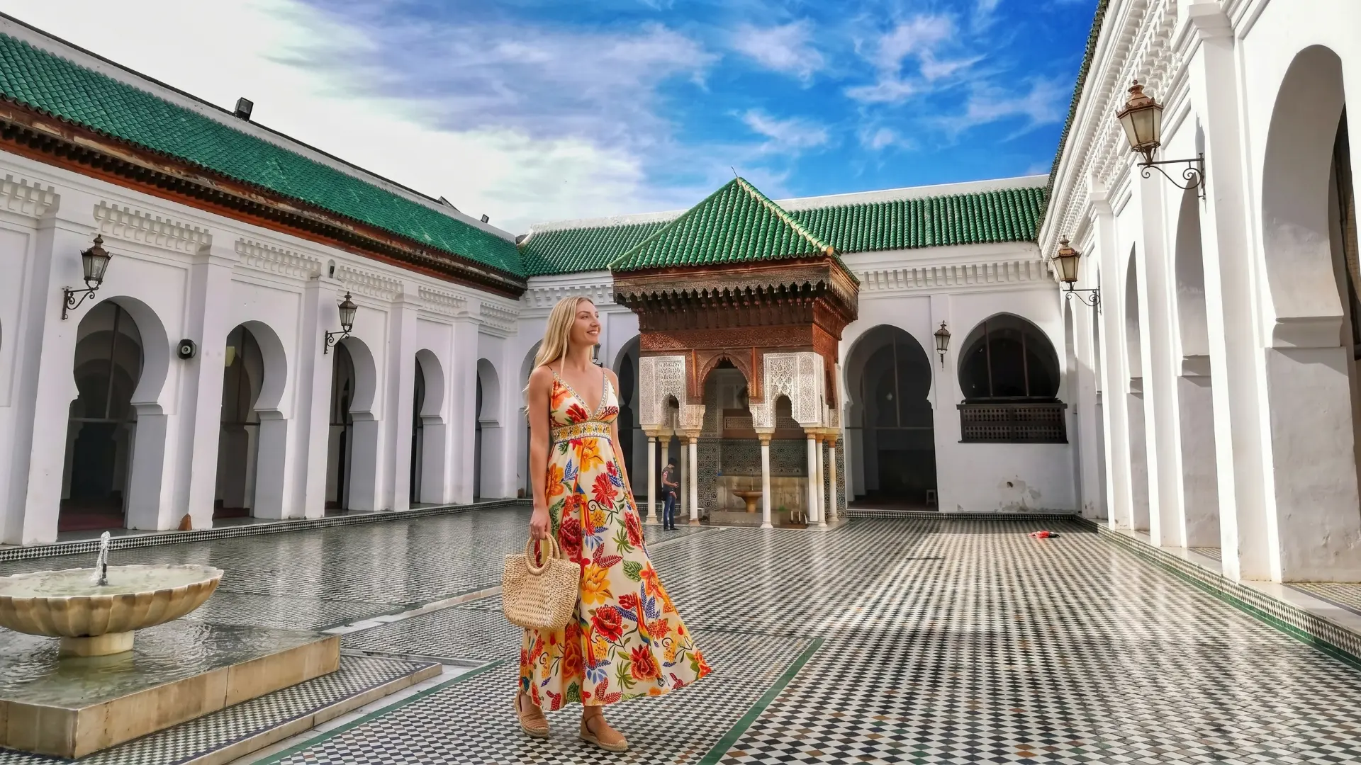 The stunning courtyard of Al-Qarawiyyin Mosque with green tiled roofs and fountain in Fez Morocco
