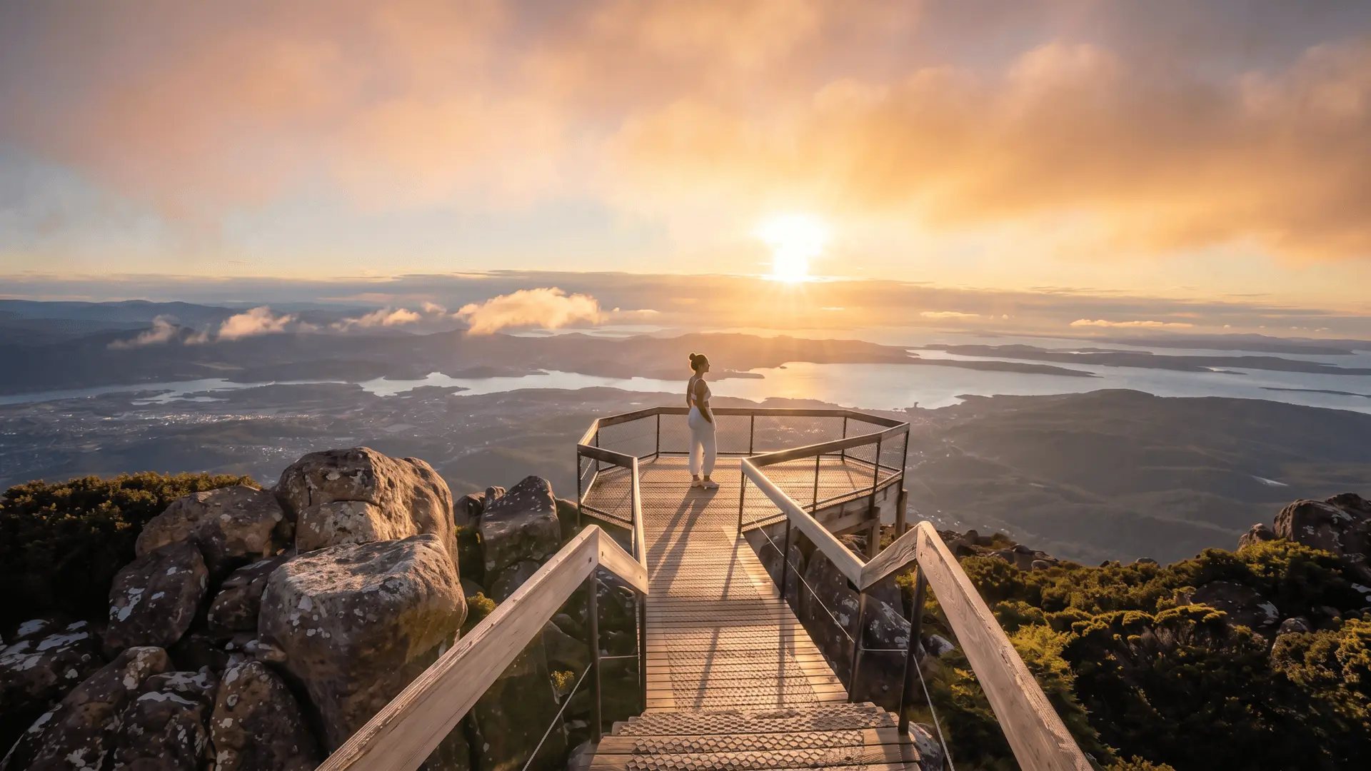 Hiking Mount Wellington during golden hour with warm sunset light over Hobart Tasmania